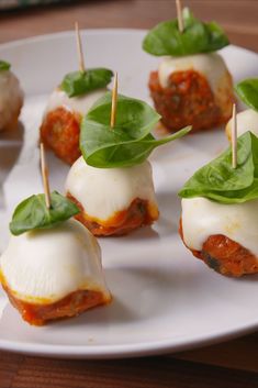 small appetizers with cheese and spinach are on a white plate, ready to be eaten