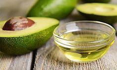 an avocado oil in a small glass bowl next to some sliced avocados