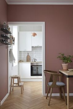 a kitchen with pink walls and wooden floors