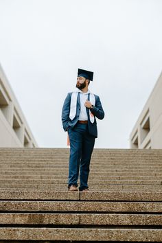 a man in a suit and tie standing on some steps with his hands behind his back