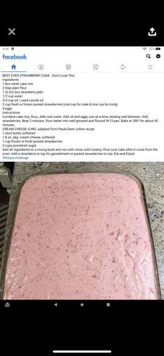 a pink cake sitting on top of a counter next to a pan filled with frosting