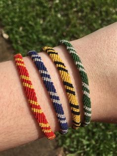 three bracelets on someone's arm with grass in the background