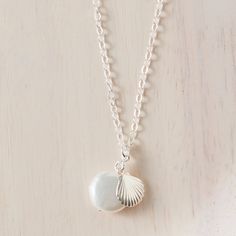 This delicate coastal necklace displays dazzling pearls and a scallop shell charm, making it the perfect gift for a beachcomber. Handmade in Lexington by My Distinct Designs. Make it a set with the matching earrings! Made in North Carolina. Shop more items made by My Distinct Designs. Silver Shell Jewelry With Pearl Charm, Nickel-free Ocean-inspired Shell As Gift, Shell-shaped Charm Necklaces Made Of Shell As Gift, White Ocean-inspired Charm Necklace For Gift, Ocean-inspired White Charm Necklace As Gift, Ocean-inspired White Charm Necklace Gift, White Shell-shaped Jewelry With Starfish Charm, White Shell Charm Necklace As Gift, White Shell Charm Necklace For Gift