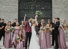 a group of people standing next to each other in front of a building with confetti