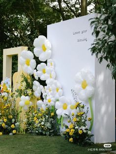 white and yellow flowers in front of a large sign