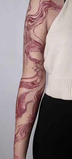 a woman's arm with tattoos on it and a white top underneath her sleeve