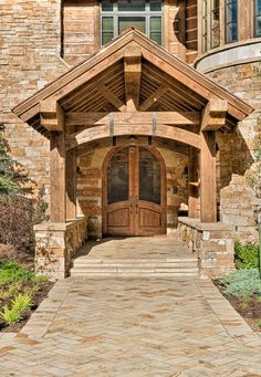 a large wooden door in front of a stone building with arched windows and brick pillars