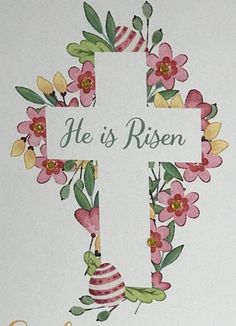 a cross with flowers and the words he is risen