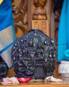 an intricately decorated black vase sitting on top of a wooden table next to other items