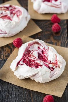 raspberry cheesecakes with whipped cream and fresh raspberries on the side