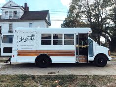 a white bus parked in front of a house