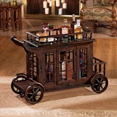 an old fashioned bar cart with wine bottles on it's top and glass doors