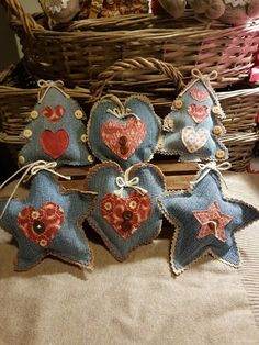 five blue and red heart shaped ornaments sitting on a table in front of a basket