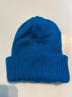 a blue knitted hat sitting on top of a white table