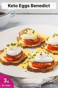 four eggs benedict on toast with tomatoes and mayonnaise in the middle, sitting on a white plate next to a cup of coffee