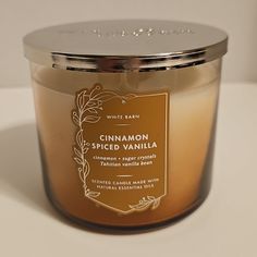 a candle with cinnamon spiced vanilla on the inside is sitting on a white surface