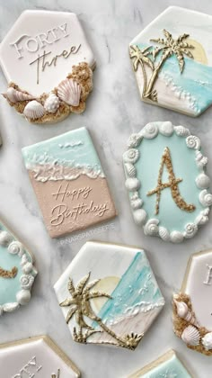 decorated cookies with beach themed icing on a marble table top, including the letter a