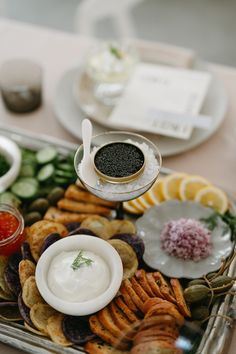 a platter with crackers, sauces and other food items on the table