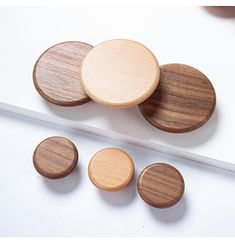 four wooden buttons sitting on top of a white surface