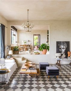 a living room filled with furniture and a chandelier hanging over the top of it