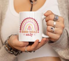 a woman is holding a coffee mug with the words good vibes only on it