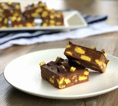 three pieces of chocolate and yellow candy on a white plate