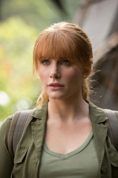 a woman with red hair wearing a green shirt