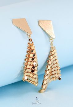 Make way for a statement like no other. These sparkling gold plated drop earrings instantly elevate any look with geometric sparkle that dances in the light. Crafted from gold plated brass for a high shine that lasts, the triangular studs frame a shimmering handkerchief design that will have heads turning. Triangle Gold Metal Earrings, Gold Triangle Metal Earrings, Trendy Gold Triangle Earrings, Geometric Gold Earrings For Party, Gold Geometric Earrings For Party, Gold Geometric Jewelry For Party, Diamond-shaped Gold Jewelry For Party, Gold Diamond-shaped Party Jewelry, Trendy Triangular Gold Jewelry