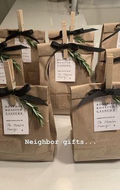 brown paper bags with black ribbon tied around them and tags attached to the handles that say, neighbor gifts