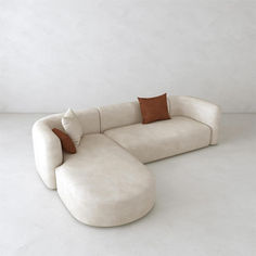 a large white couch with pillows on it's back and side ends, sitting in front of a wall