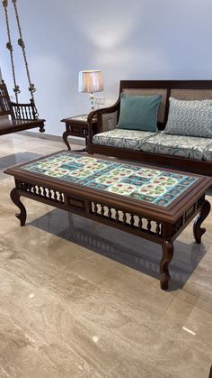 a living room with two couches, a coffee table and a swing in the background