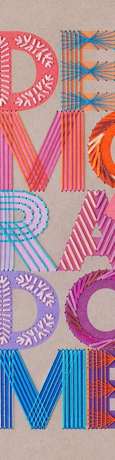 the letters are made up of different colored yarns and paper straws with scissors on them