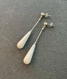 Long just over 2 inch (5cm) earrings handmade with Mother of Pearl drops and Sterling Silver 925. Sterling Silver stud ear fittings. Can be changed to clip on ear fittings, please add a message to your order if you require this. The earrings are long but they're very light to wear. Perfect for a long day at a wedding, at the races or for any special occasion. All jewellery is handmade by me in my home studio. Earrings come in a presentation gift box. Modern White Clip-on Jewelry, Classic White Long Drop Bridal Earrings, White Long Drop Teardrop Earrings, White Sterling Silver Long Drop Earrings, White Teardrop Minimalist Bridal Earrings, Classic White Drop Linear Earrings, White Drop Linear Earrings, White Minimalist Long Drop Earrings, Classic White Dangle Clip-on Earrings