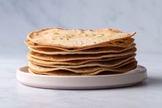 a stack of tortillas sitting on top of a white plate