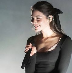 a woman wearing ear buds and holding a microphone