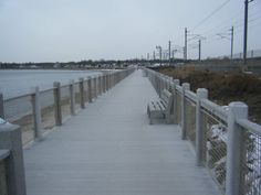 a wooden bench sitting on top of a pier next to the ocean