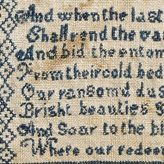 an embroidered sample of the text in blue and white, with some writing on it