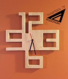 a clock made out of white wood with black and red hands on an orange wall