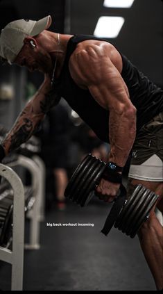 a man doing squats with dumbbells in a gym