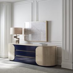 a white and blue sideboard in a room with a painting on the wall behind it