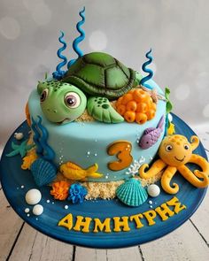 a birthday cake with an ocean theme and sea animals on the bottom, including a turtle