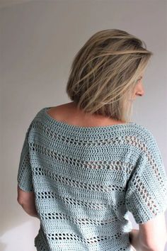 a woman wearing a blue crochet top with short sleeves and an open back