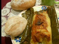 a plate with some food on it next to bread and a cup of green tea