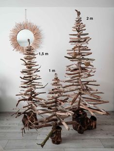 driftwood christmas tree in front of a mirror on the floor with logs and branches around it