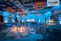 a banquet room with blue lighting and round tables