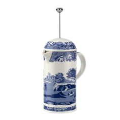 a blue and white coffee pot with a spoon in it's handle on a white background