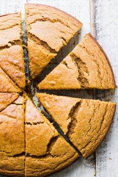 a sliced loaf of bread sitting on top of a white wooden table next to a knife