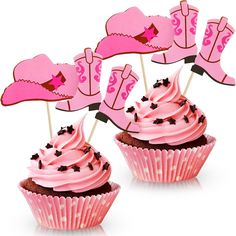 cupcakes with pink frosting and cowboy boots on top are sitting next to each other