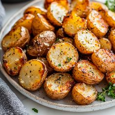 a white plate topped with potatoes covered in parmesan cheese