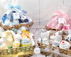 two baskets filled with baby items sitting on top of a wooden table next to each other